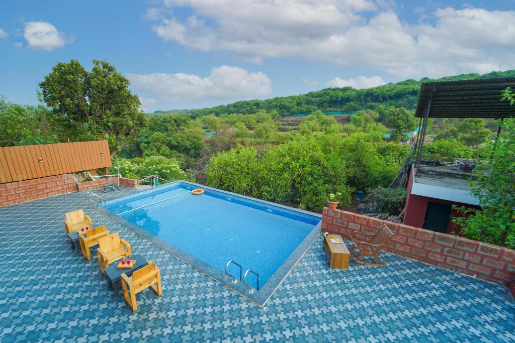 a swimming pool with some chairs at Treebo La Paradise in Mahabaleshwar