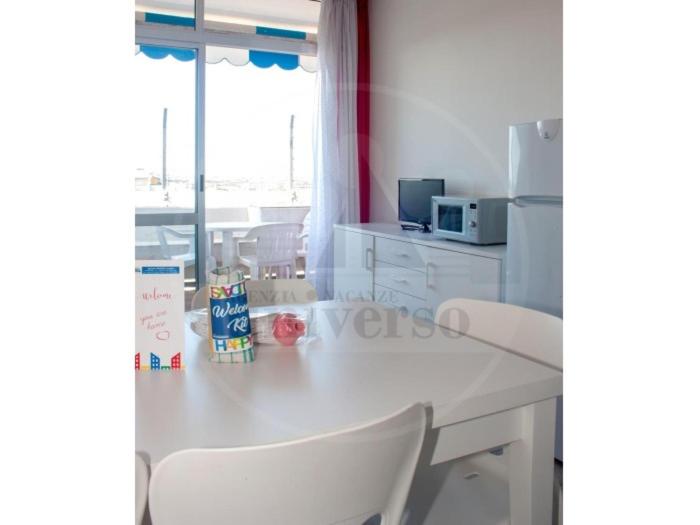 a kitchen with a white table and white chairs at Plaza in Eraclea Mare