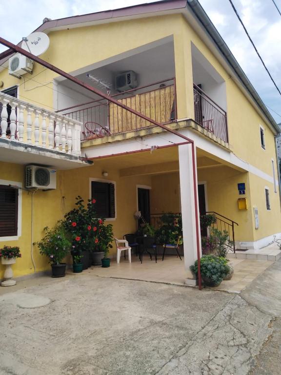 a yellow house with a balcony and a patio at Ivan in Starigrad-Paklenica