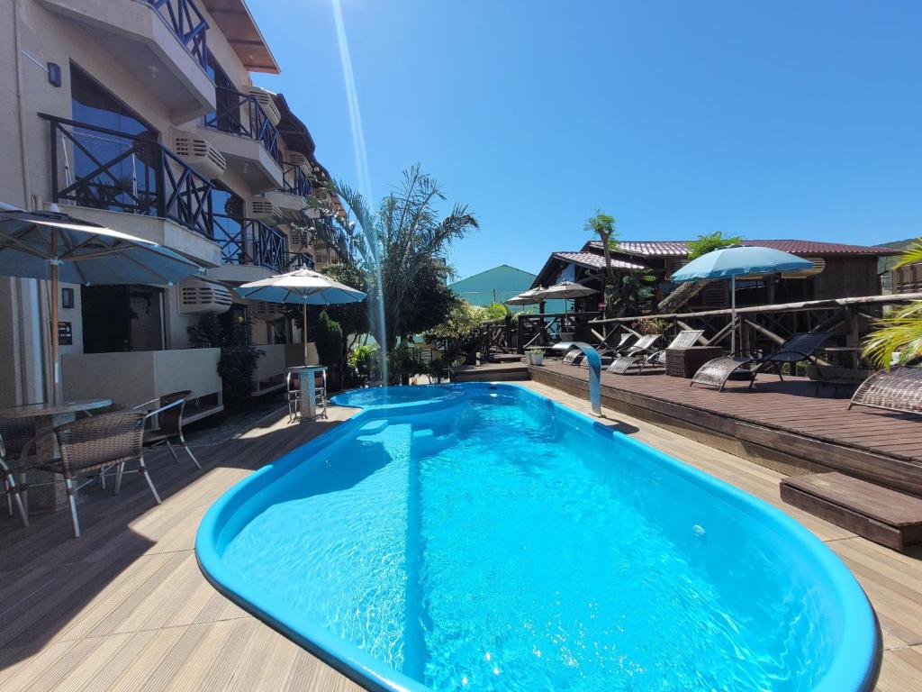 uma grande piscina azul ao lado de um edifício em Pousada Recanto do Aconchego em Florianópolis