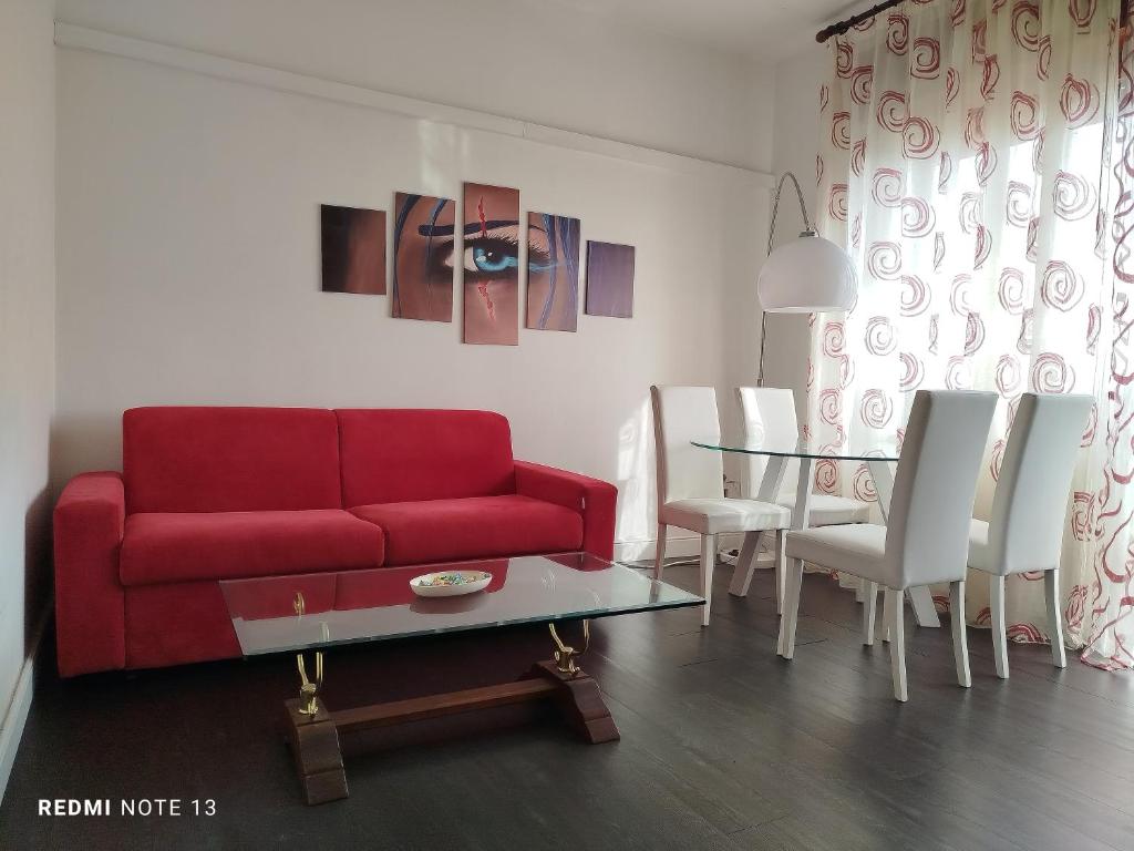 sala de estar con sofá rojo y mesa de cristal en Casa Aris Fiera Vicenza, en Vicenza