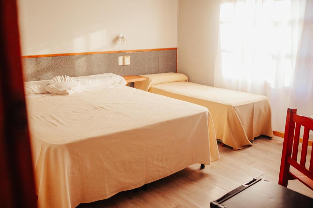 En eller flere senge i et værelse på HOTEL REALICO