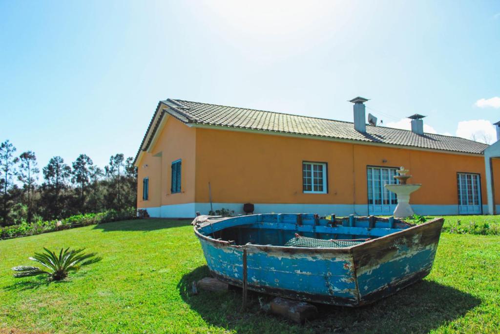 una barca blu seduta sull'erba di fronte a una casa di Vila Almeida a Ponta Delgada