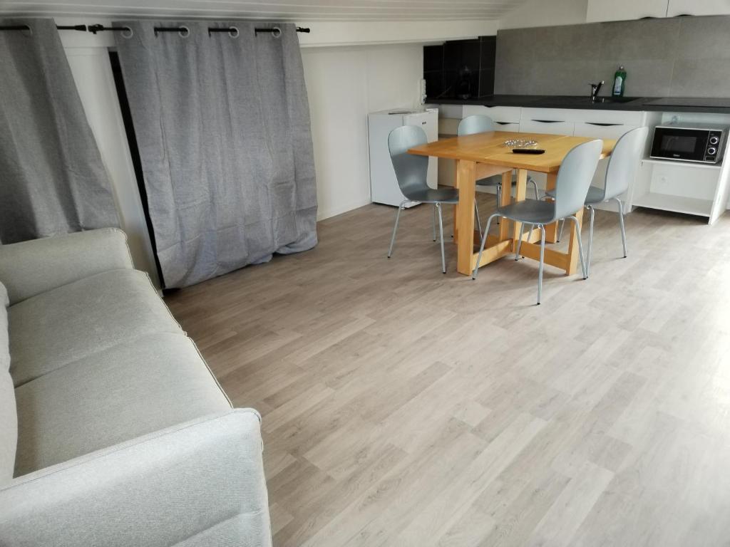 sala de estar con mesa y sillas y cocina en Chez Mimi 1,7 kilomètres de Luxeuil les Bains, en Froideconche