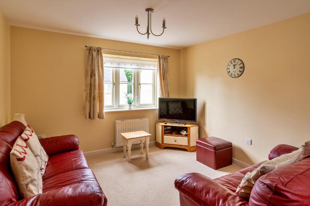 a living room with a couch and a television at Finest Retreats - Hardie Close in Tetbury