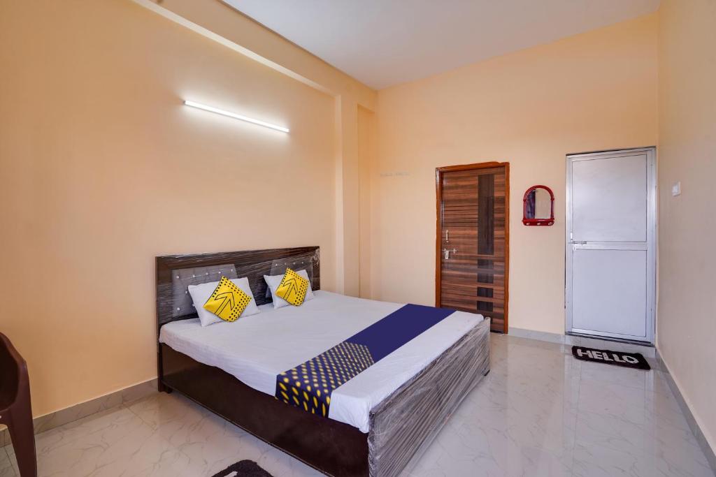 a bedroom with a bed with yellow and blue pillows at SPOT ON Hotel Pragya 5 in Raipur