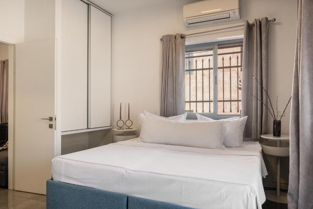 een slaapkamer met een bed en een raam bij dining room, bedroom and balcony in Jeruzalem
