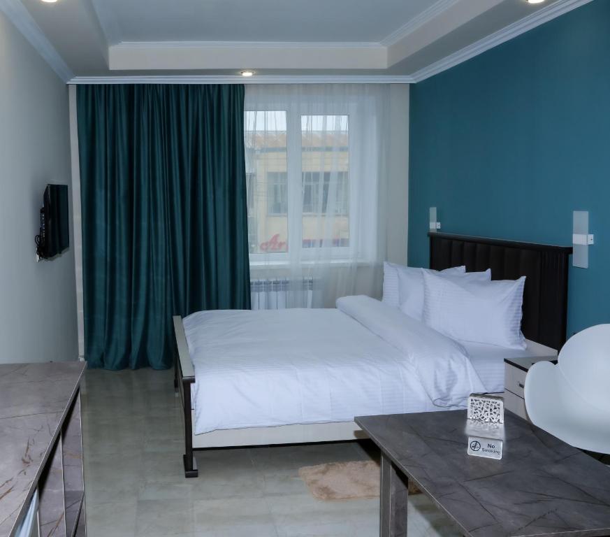 Martuni的住宿－Vell Grey Hotel，卧室设有一张白色大床和一扇窗户。