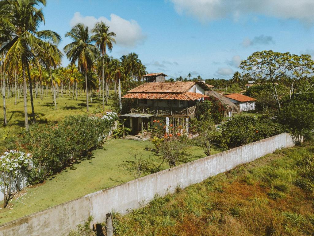 an old house in a field with palm trees at Pousada Casa Branca in Pôrto de Pedras
