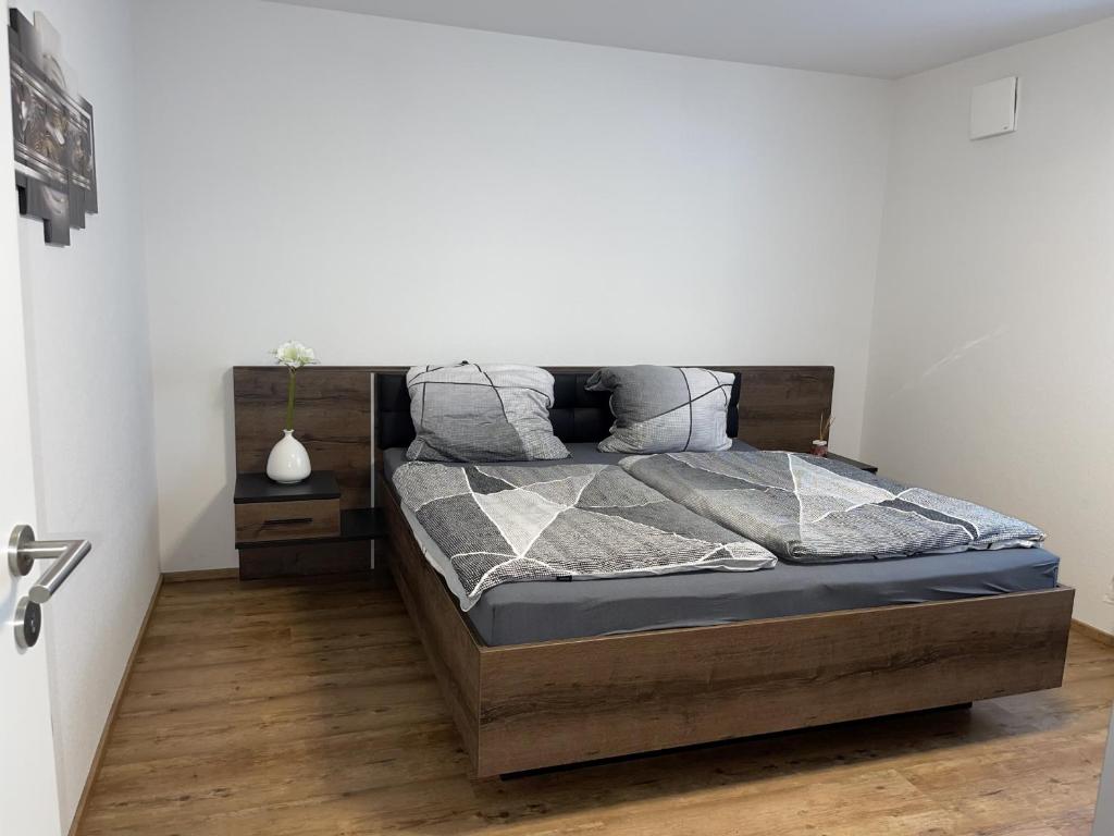 1 dormitorio con 1 cama con cabecero de madera en Kleine Auszeit, en Friedrichshafen