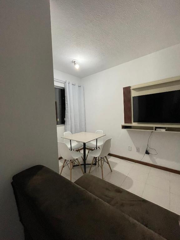a living room with a table and a television at Apartamento aconchegante 2 in Jequié