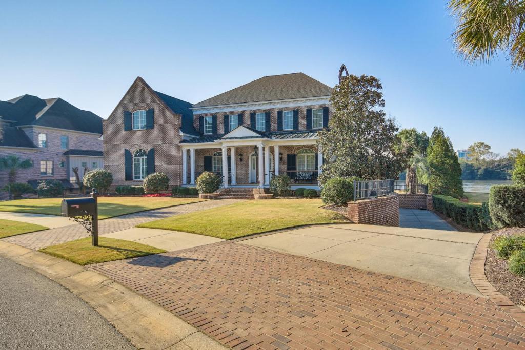 a large house with a brick driveway at Riverfront North Augusta Home with Private Pool! in North Augusta