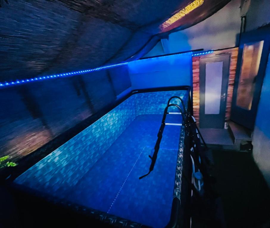 a swimming pool with blue lights in a building at La piscine en prairie in Saint-Amarin