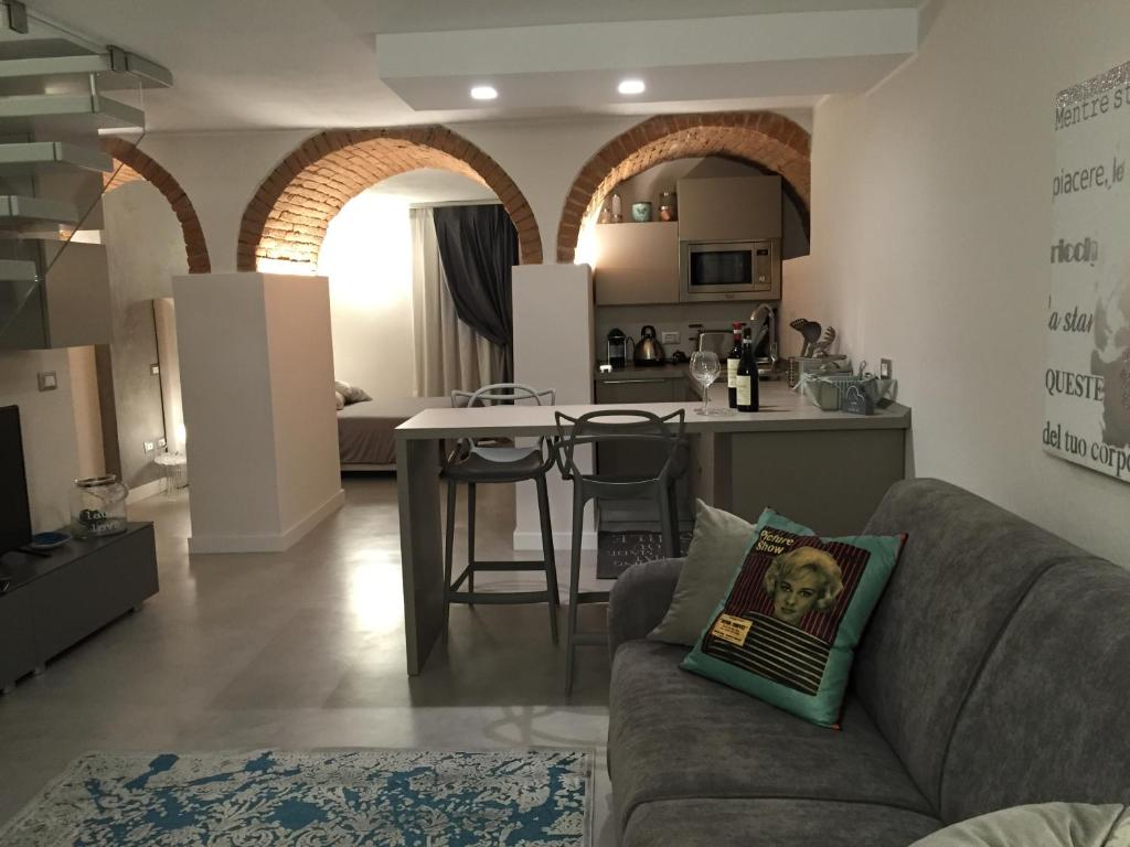 ein Wohnzimmer mit einem Sofa und einer Küche in der Unterkunft L'Angolino Nascosto in Verona