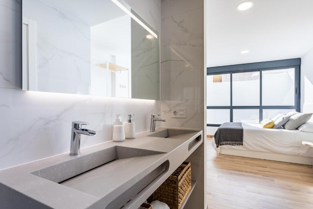 a white bathroom with a sink and a bed at Sunny island atico cruz in San Andrés