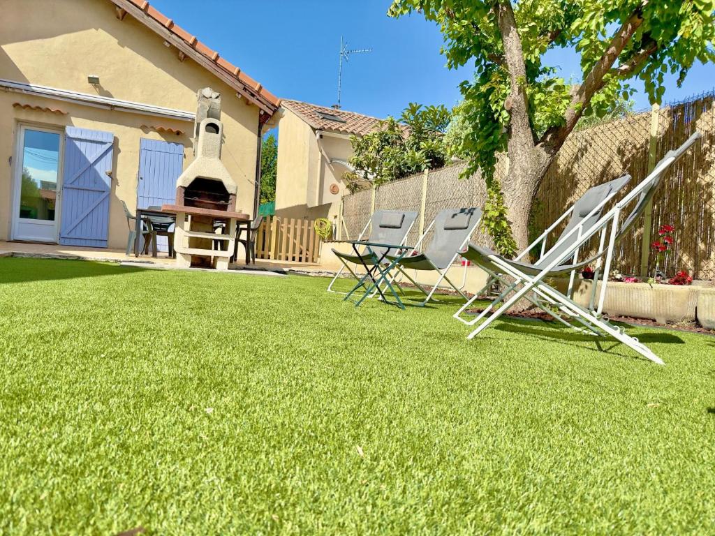 two lawn chairs and a swing in a yard at Maison Confort & Silence, Jardin & Barbecue in Marseille