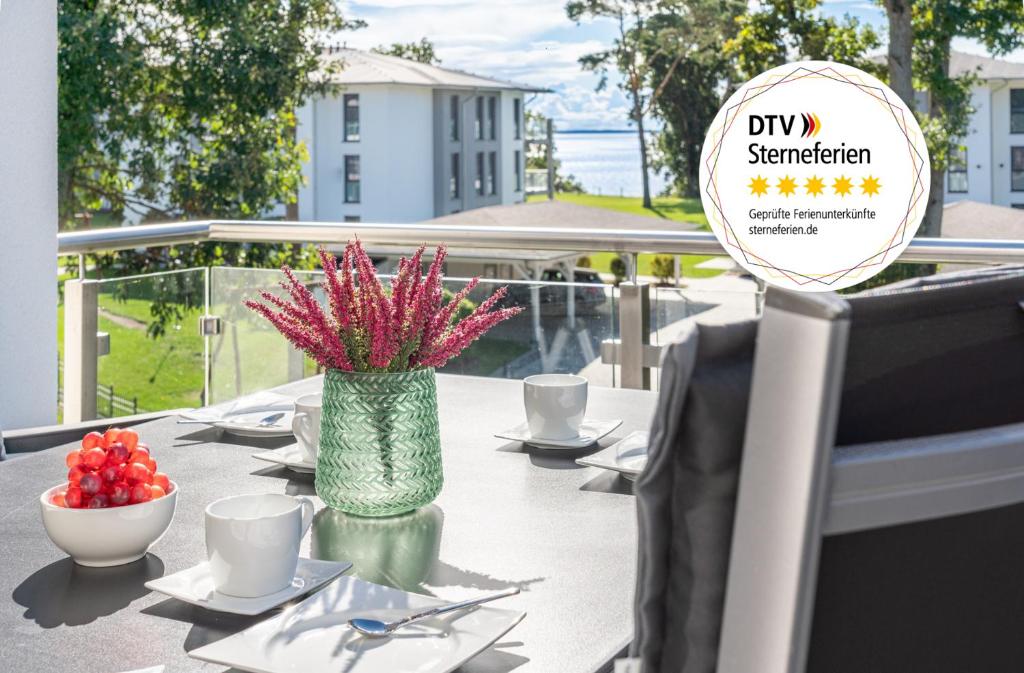 a table with a vase with flowers on it at Apartment "Sonnendeck" - Haffresidenz in Zirchow