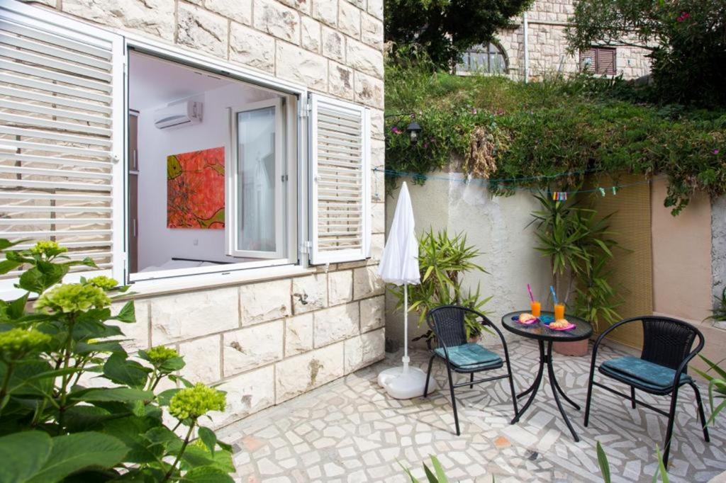 a patio with two chairs and a table and a window at Apartment Banjska in Dubrovnik
