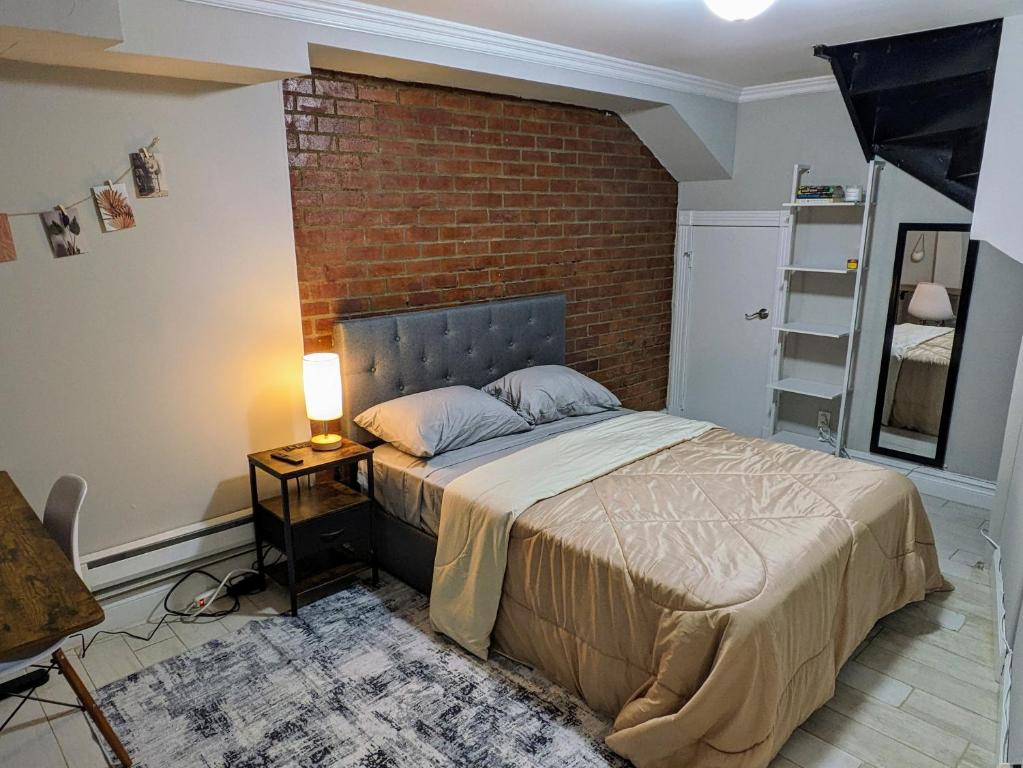 Private Room at a shared Apartment at the Heart of East Village في نيويورك: غرفة نوم بسرير وجدار من الطوب