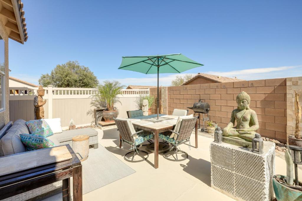 un patio con una mesa y una sombrilla verde en Charming Henderson Home 6 Mi to Lake Las Vegas!, en Las Vegas