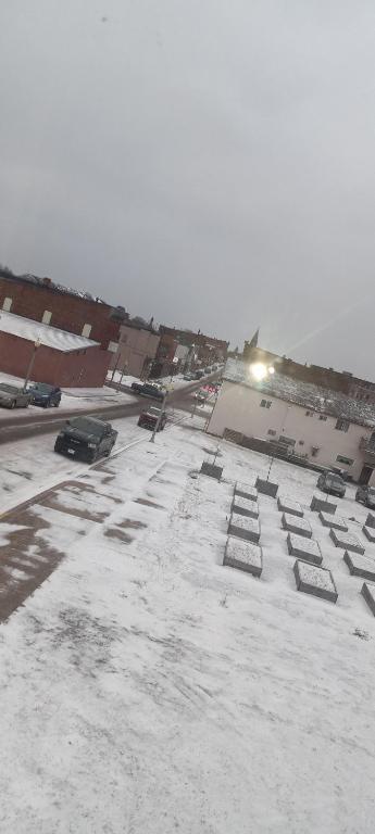 parking pokryty śniegiem z zaparkowanymi samochodami w obiekcie Convenient with a view of downtown w mieście Calumet