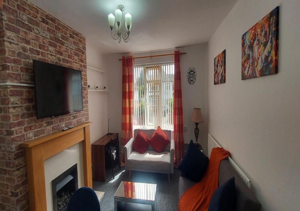 a living room with a fireplace and a television at Coventry 59 Michaelmas Pet Friendly 2 Bedroom Apt with Parking in Parkside