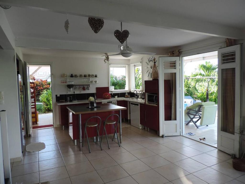 une cuisine avec une table et quelques chaises dans l'établissement Villa de caractère ,3 étoiles, avec piscine, jardin et plage à 200m, à La Trinité
