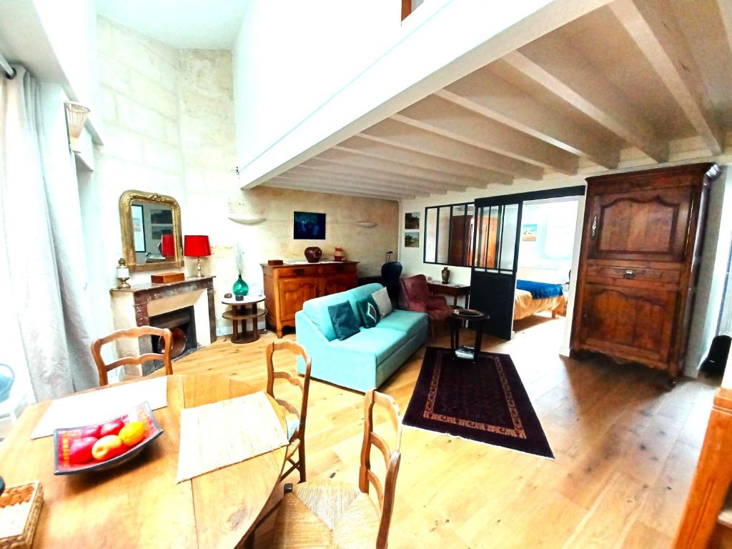 un salon avec une table et un canapé bleu dans l'établissement L'échoppe sur la place, à Bordeaux