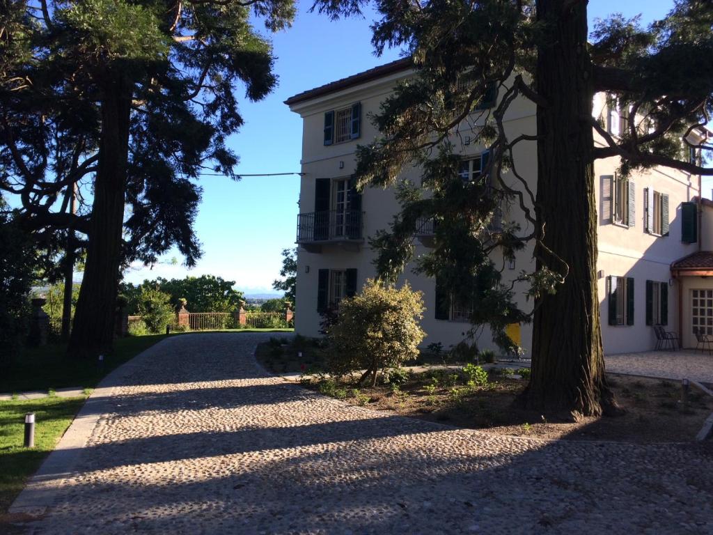 a road leading to a white house with trees at Casa Rita, Charming House with pool, Asti in Asti