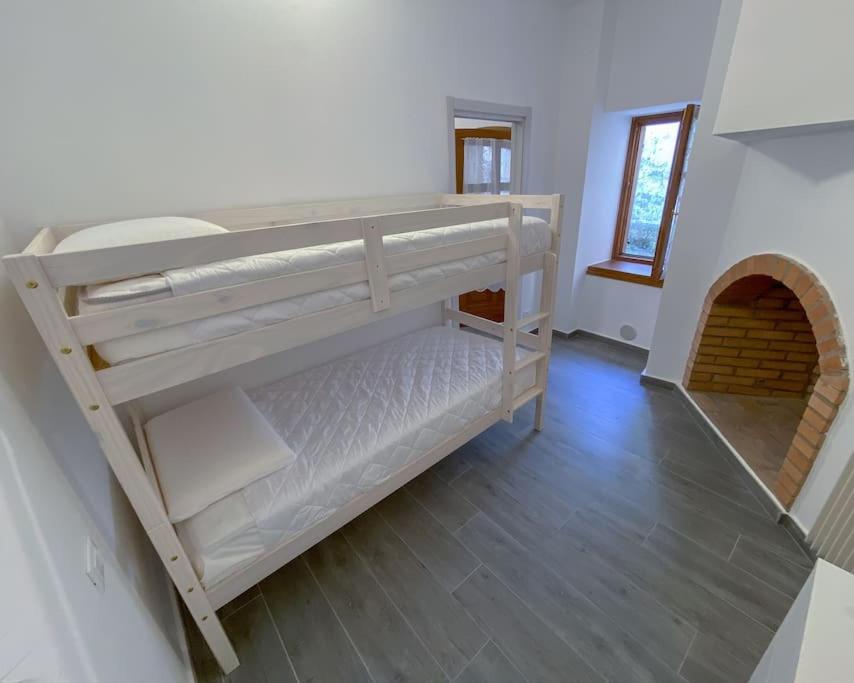 レーヴィコ・テルメにあるAppartamento La Corteのベッドルーム1室(二段ベッド2組付)