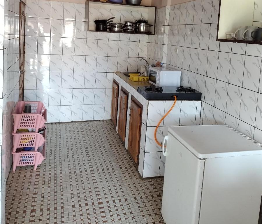 雅溫德的住宿－Appartement biteng，厨房铺有白色瓷砖地板,配有冰箱。
