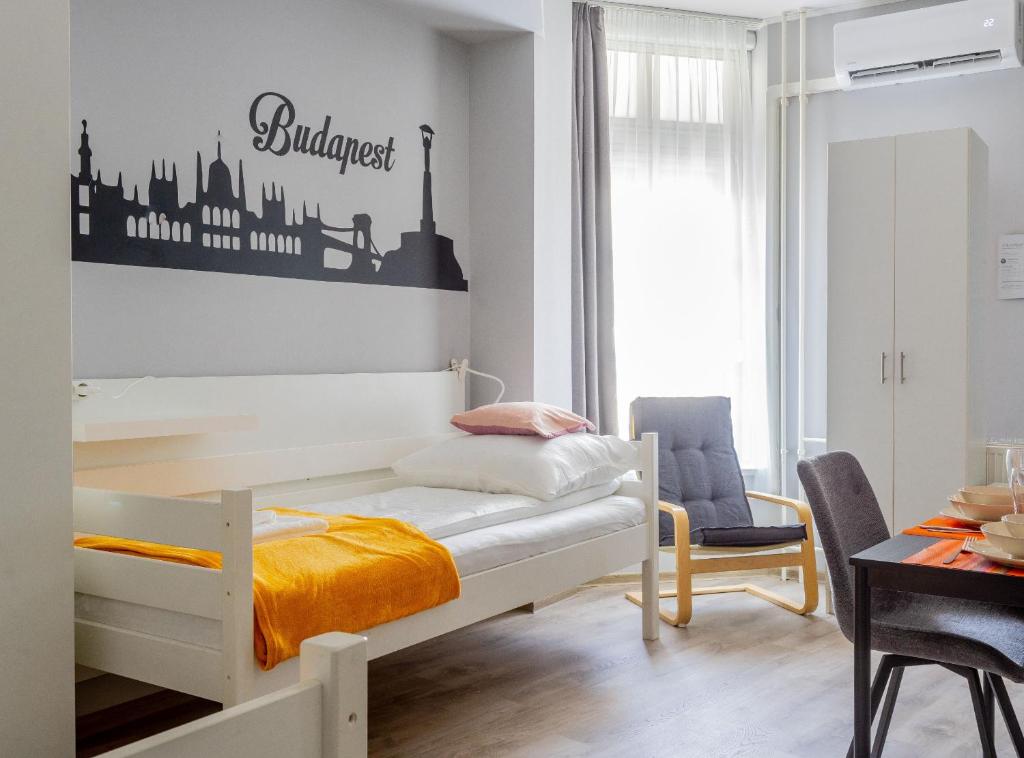 Downtown Apartment House Orange في بودابست: غرفة نوم صغيرة مع سرير وطاولة