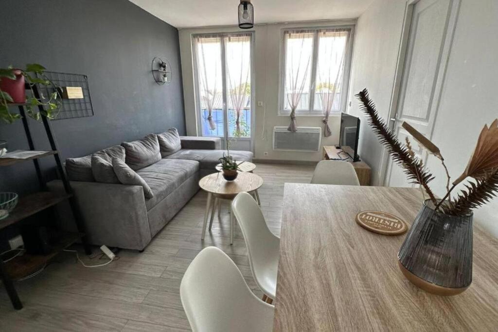 - un salon avec une table et un canapé dans l'établissement Joli appartement près de Rouen, à Le Petit-Quevilly