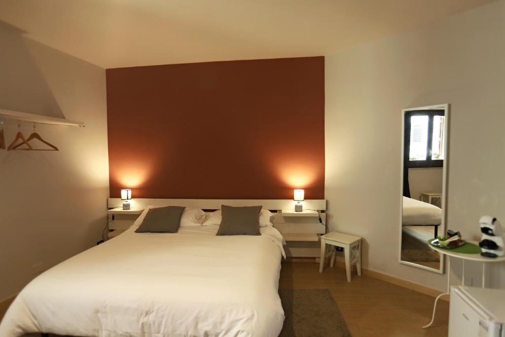 1 dormitorio con 1 cama blanca grande y 2 lámparas en Le Chiavi, en Erice