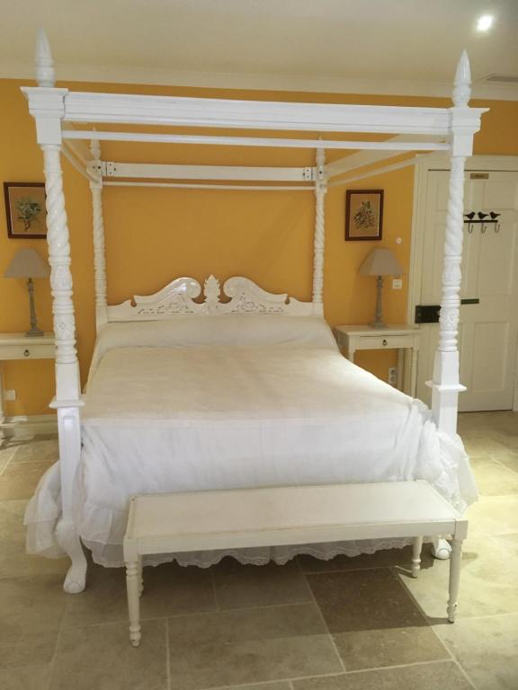 uma cama de dossel branca num quarto em Chambre d'Hôte Couguiolet - avec piscine em Foissac