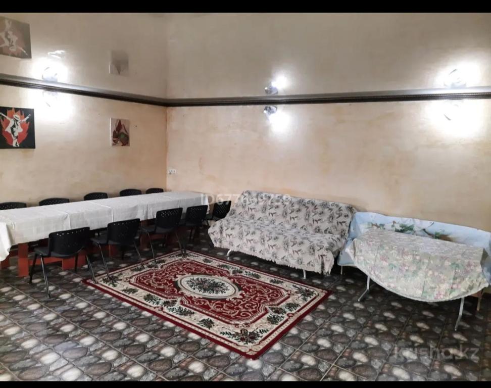 Habitación con mesa, sillas y alfombra. en Lastochka en Imeni Telʼmana