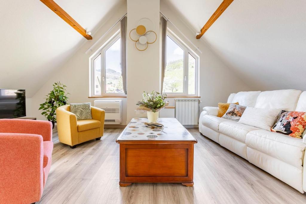 Sala de estar con sofá blanco y mesa de centro en Les Glycines du Sommerberg en Niedermorschwihr