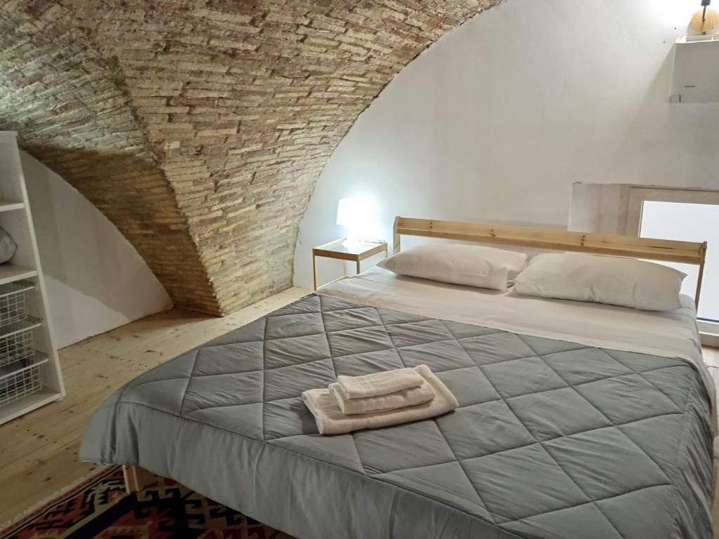 um quarto com uma cama grande e uma parede de tijolos em GiuattyHomeHoliday Termoli em Termoli