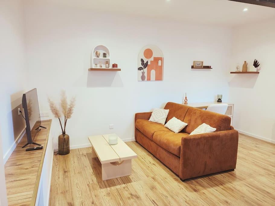 sala de estar con sofá marrón y mesa en Au rue du gaz YourHostHelper, en Rodez