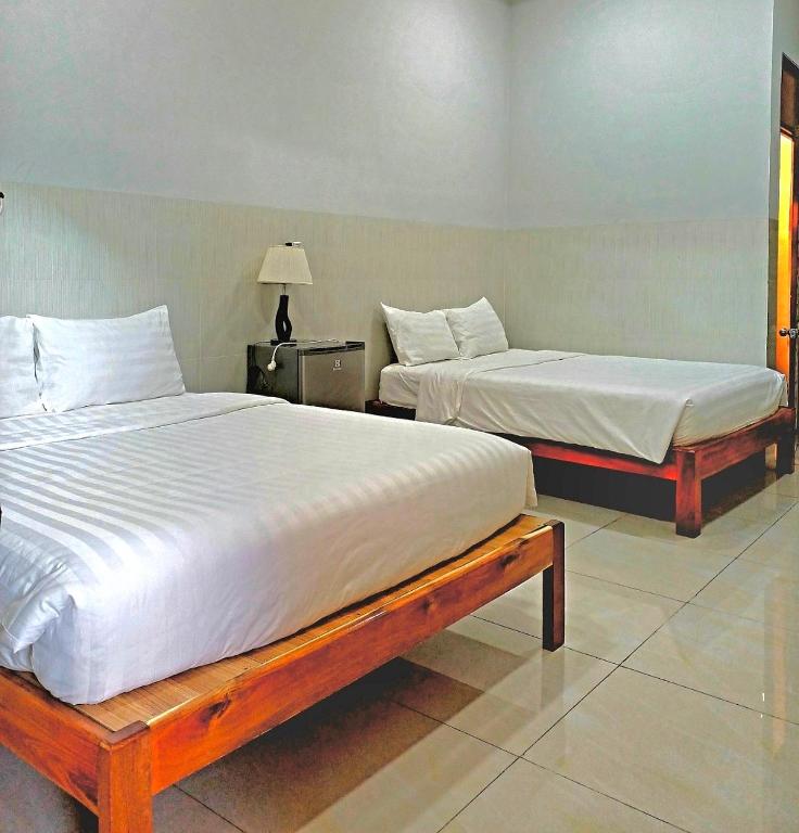 two beds in a room with two beds sidx sidx sidx at NGUYỆT MINH HOTEL in Ấp Phú Lợi