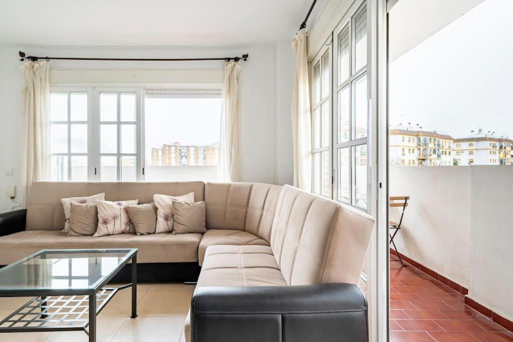 a living room with a couch and a glass table at Centric and spacious flat with free car park in Seville