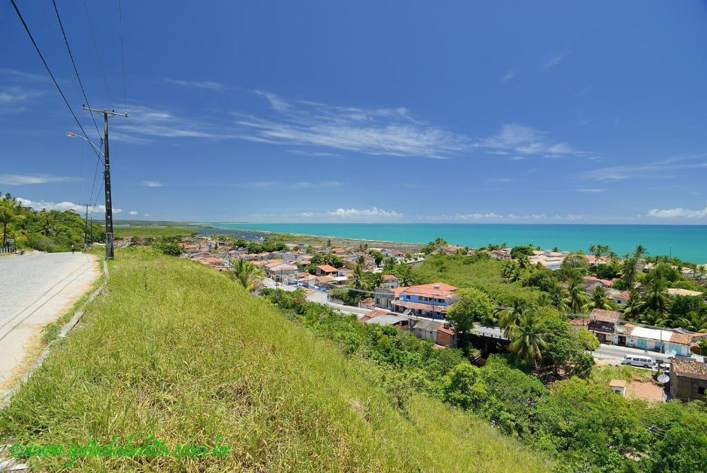 a view of a city from a hill with the ocean at Beleza e praticidade no bairro Mirante in Santa Cruz Cabrália