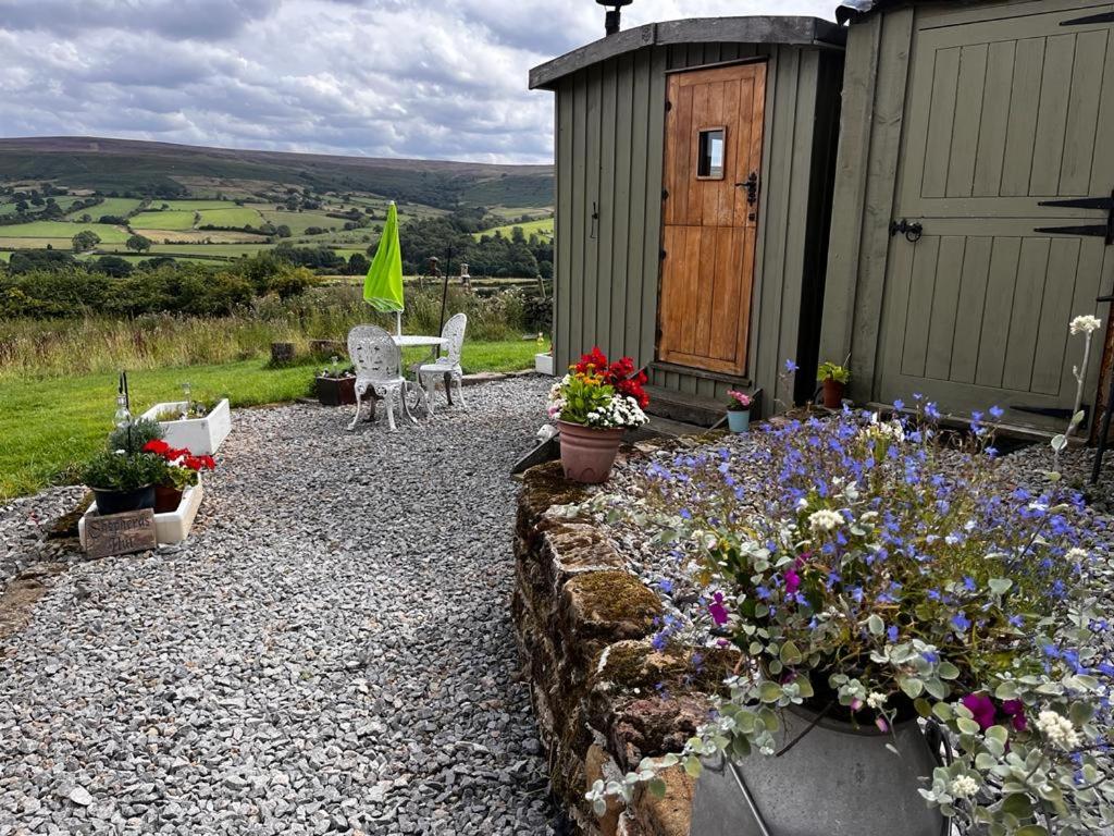 a garden with flowers in front of a building at Shepherd's Hut Bilsdale in Chop Gate