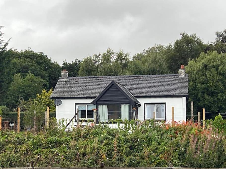 a small white house with a black roof at Station Cottage in Fort William