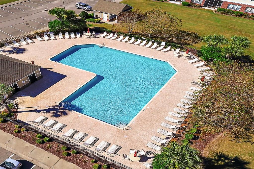 an overhead view of a large swimming pool with lounge chairs at Havens #1123 condo in North Myrtle Beach