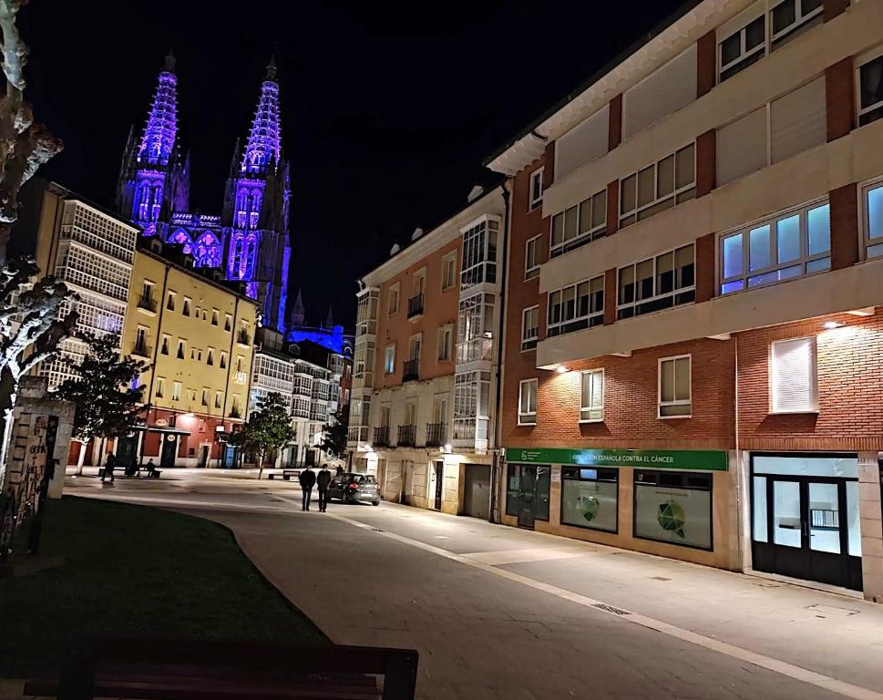 a city street at night with a building with purple lights at Apartamento en la Catedral in Burgos