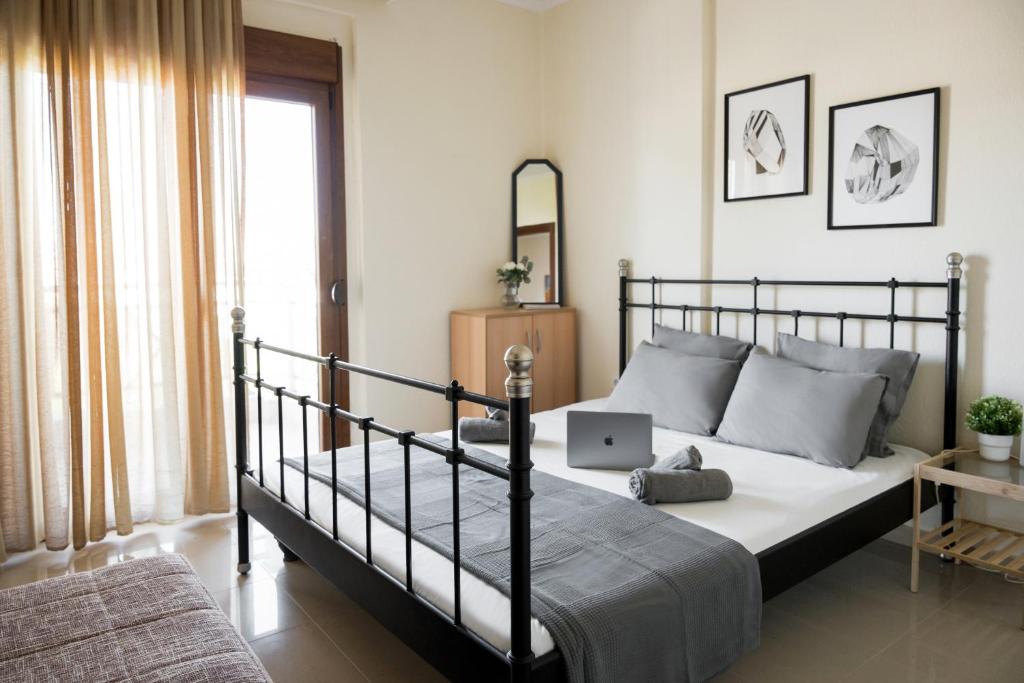 een slaapkamer met een bed met een laptop erop bij Peraia Deluxe Apartment in Perea