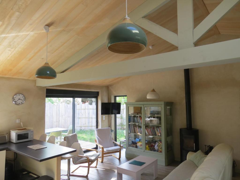a living room with a white couch and a table at La Belle Insulaire, Vertbois plage, forêt, vélos, wifi in Dolus d'Oléron
