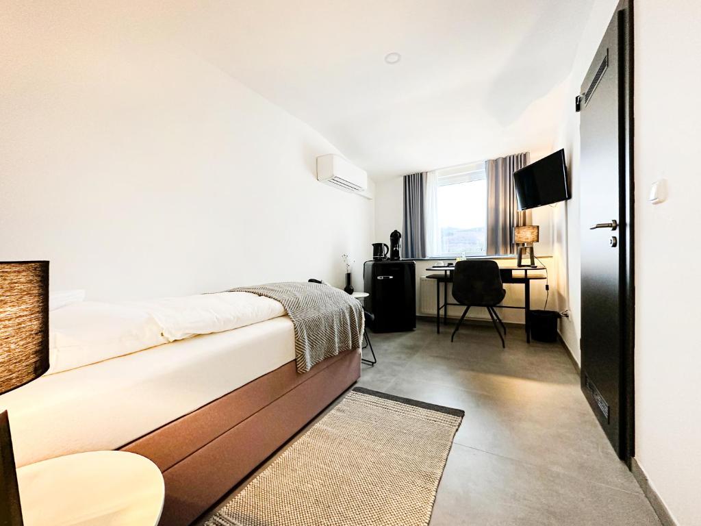 a bedroom with a bed and a desk at SI-View Einzelzimmer Zimmer 24 - Hotel in Siegen