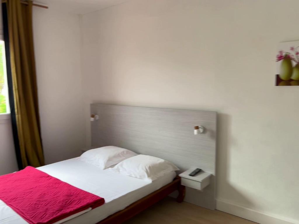 a bedroom with a bed with a red blanket on it at GITE PEI LA VANILLE "Studio Cosy en Bord de Nature" in Sainte-Suzanne